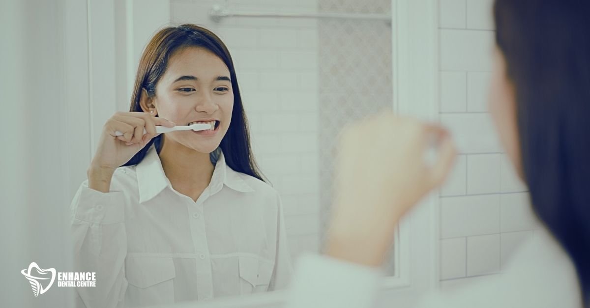 Person brushing and flossing teeth before reinserting Invisalign aligners