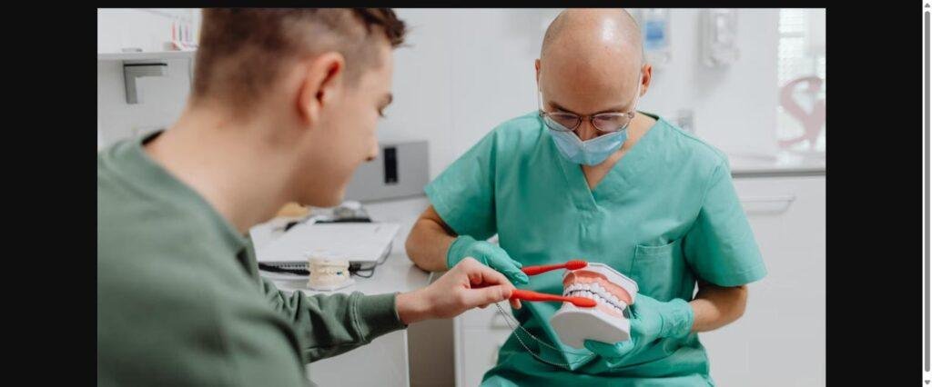 Dentist showing brushing technique to a patient at a family dental clinic in Kitsilano