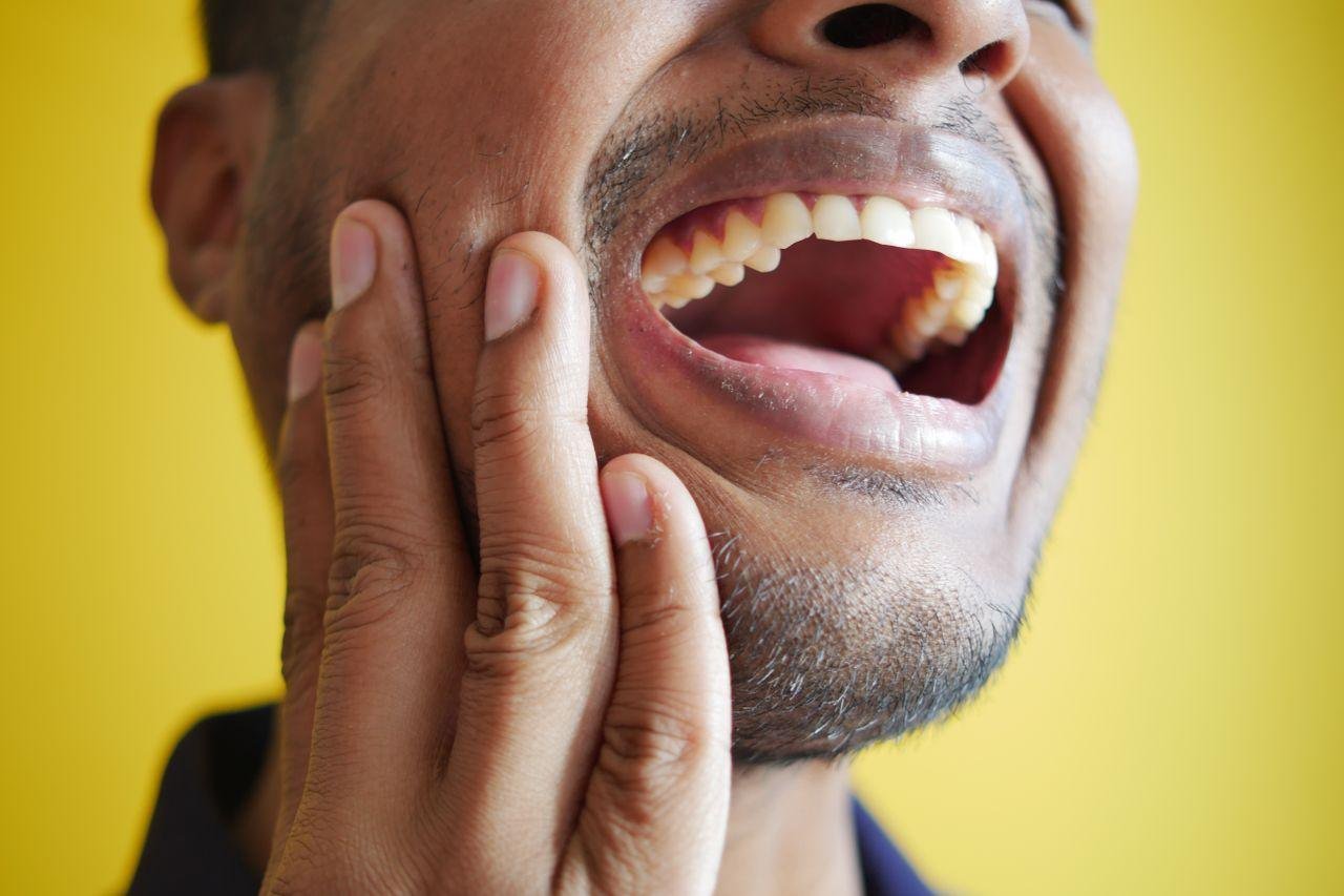 Man holding his cheek due to sensitive teeth in Kitsilano