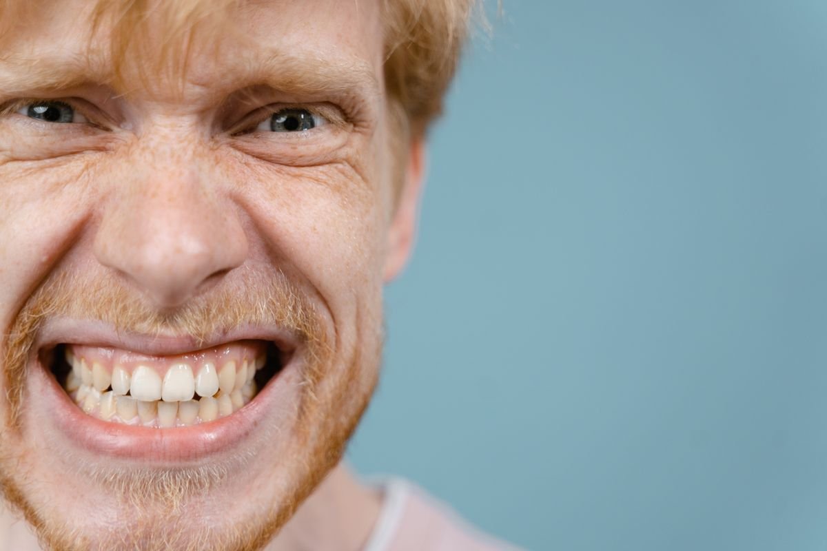 Man with jaw tension from grinding teeth at night