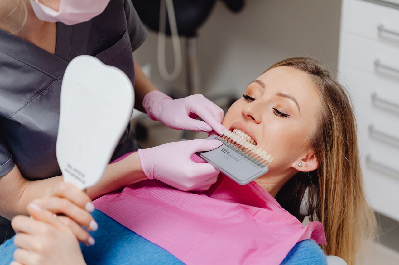 Dentist holding a shade guide in front of a patient