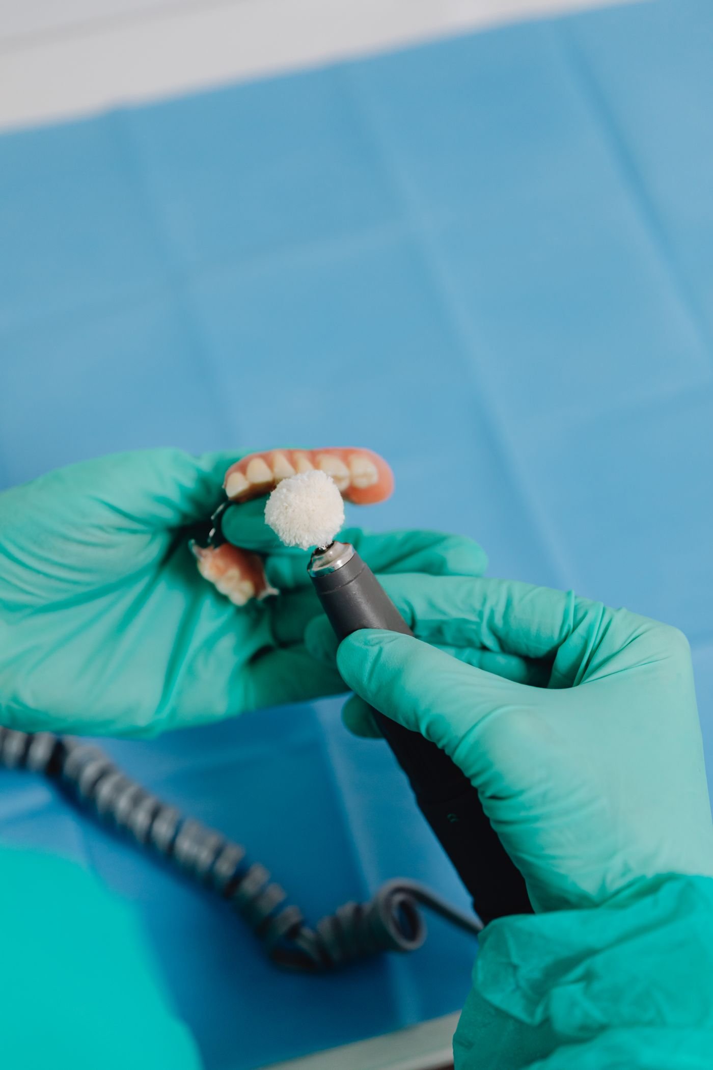 Dental professional cleaning a full denture for a patient in Vancouver