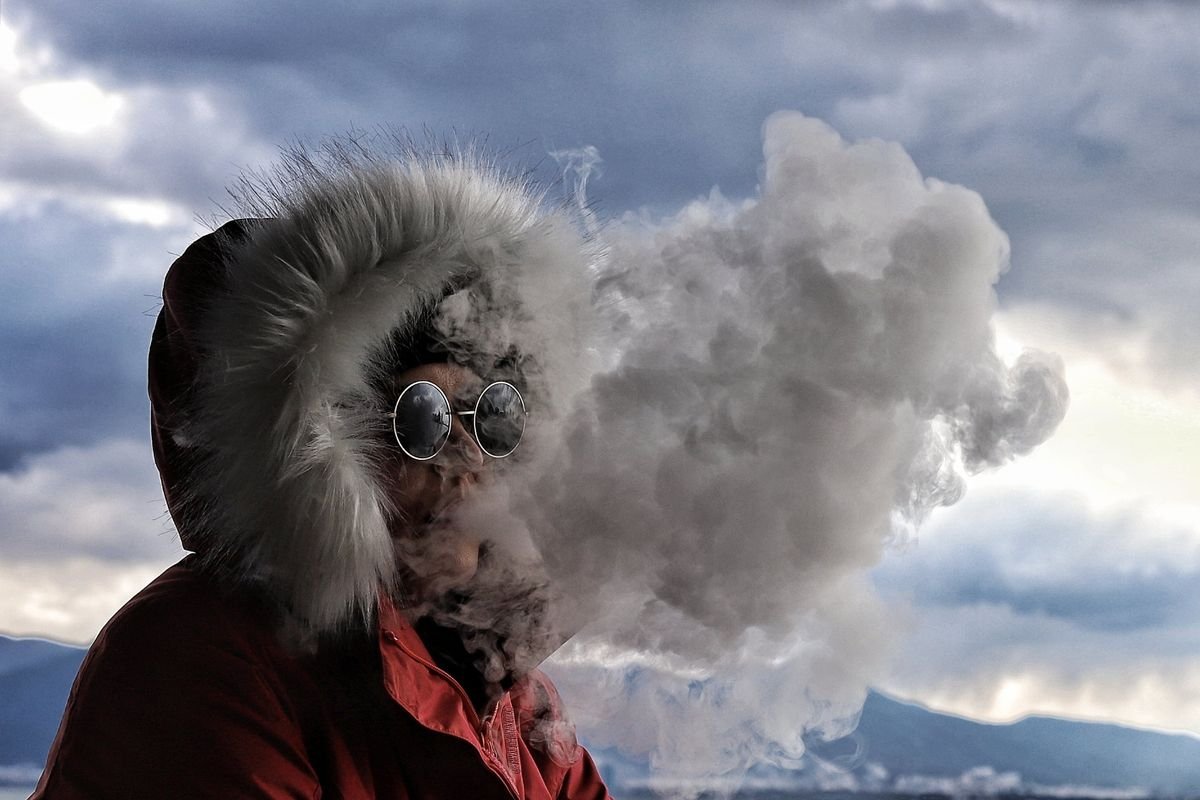 Person exhaling vapour outdoors in winter