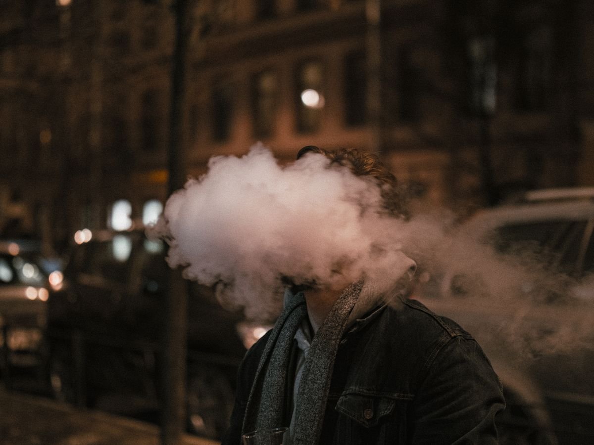 Man exhaling a thick cloud of vapour