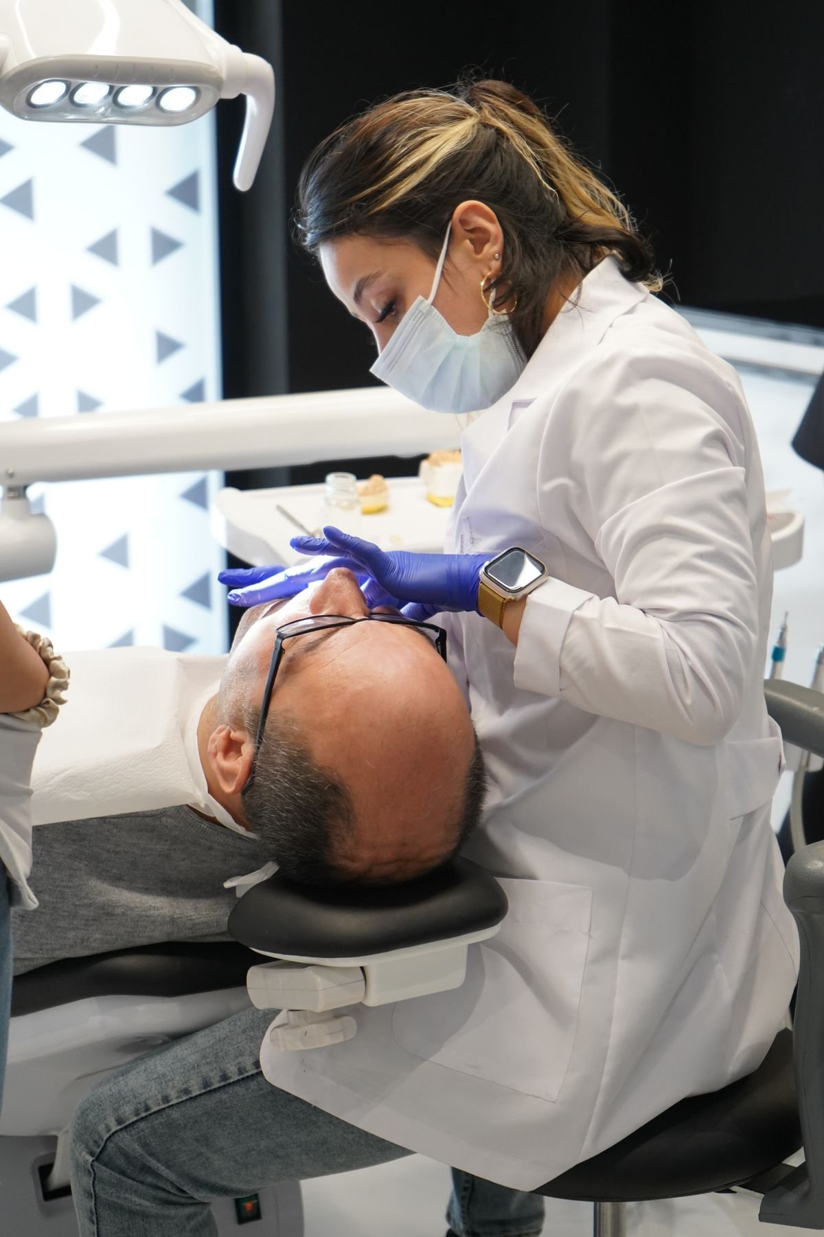 Dentist in a white coat examining a patient